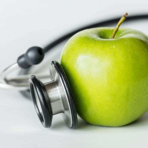 Closeup of an apple and a stethoscope healthy food and health concept